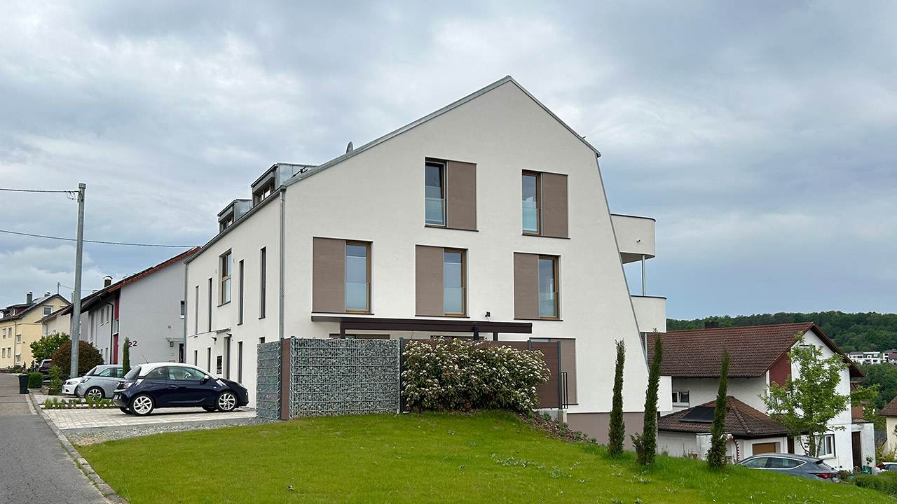 Foto der Seitenansicht von oben eines modernen Mehrfamilienhauses von außen.