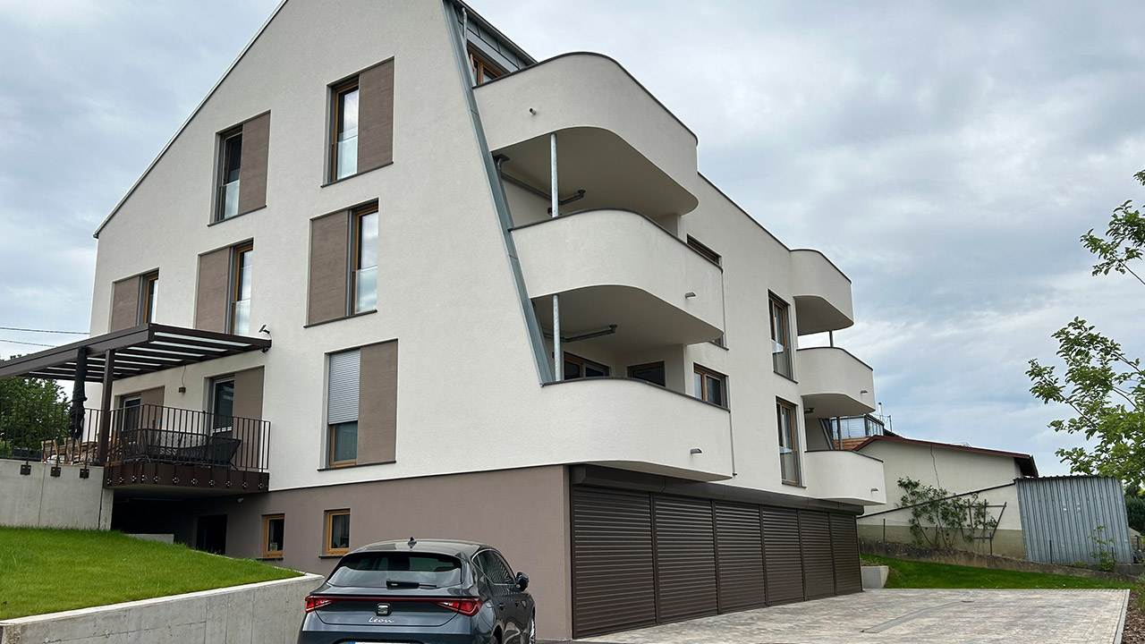 Foto der Garageneinfahrt eines modernen Mehrfamilienhauses von außen.