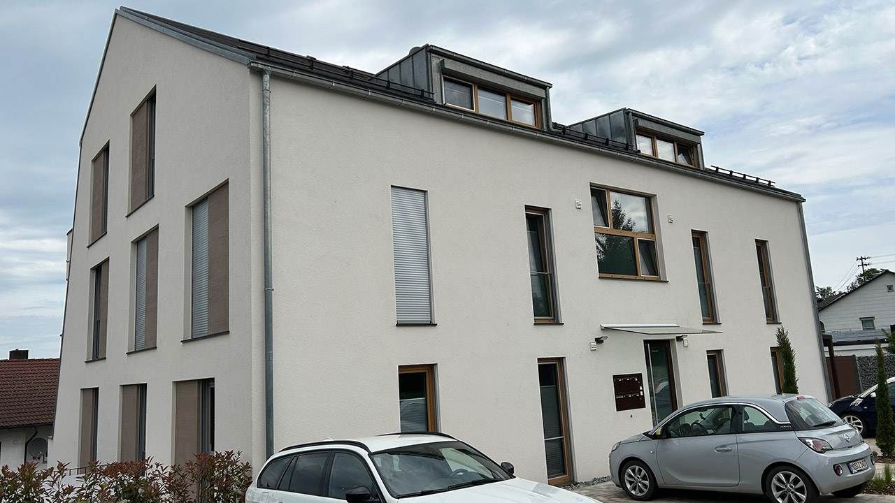 Foto des Eingangs eines modernen Mehrfamilienhauses von außen.